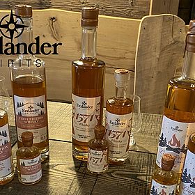 Sportpark Rabenberg EURORANDO 2026 Aussteller: Erzlander Spirits Mehrere Flaschen verschiedener Größen mit Erzlander Whisky stehen auf einem Holztisch.