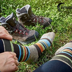 Sportpark Rabenberg EURORANDO 2026 Aussteller: WRIGHTSOCK Beine mit bunten Wandersocken und Wanderschuhe im Gras, eine Hand zieht eine Socke hoch.