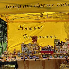 Sportpark Rabenberg EURORANDO 2026 Aussteller: Imkerei Weiße Frau hinter einem Stand mit Honig und Bienenprodukten. Viele Gläser und Tiegel sind ausgestellt.
