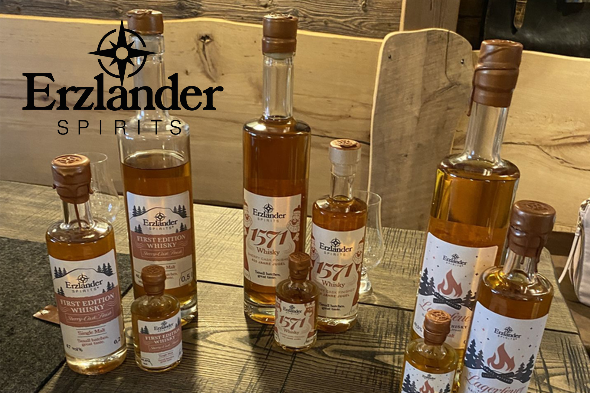 Sportpark Rabenberg EURORANDO 2026 Aussteller: Erzlander Spirits Mehrere Flaschen verschiedener Größen mit Erzlander Whisky stehen auf einem Holztisch.