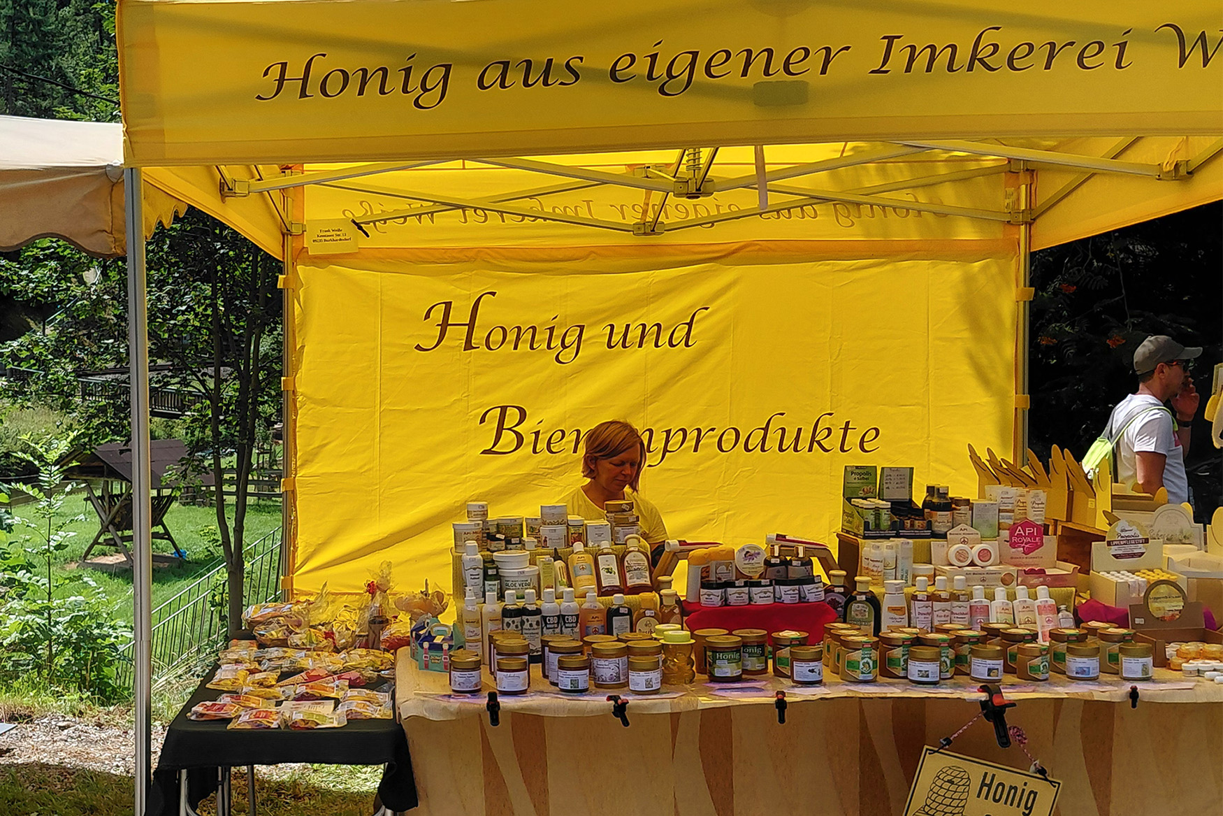 Sportpark Rabenberg EURORANDO 2026 Aussteller: Imkerei Weiße Frau hinter einem Stand mit Honig und Bienenprodukten. Viele Gläser und Tiegel sind ausgestellt.